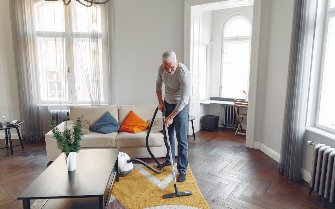 man vacuuming carpet